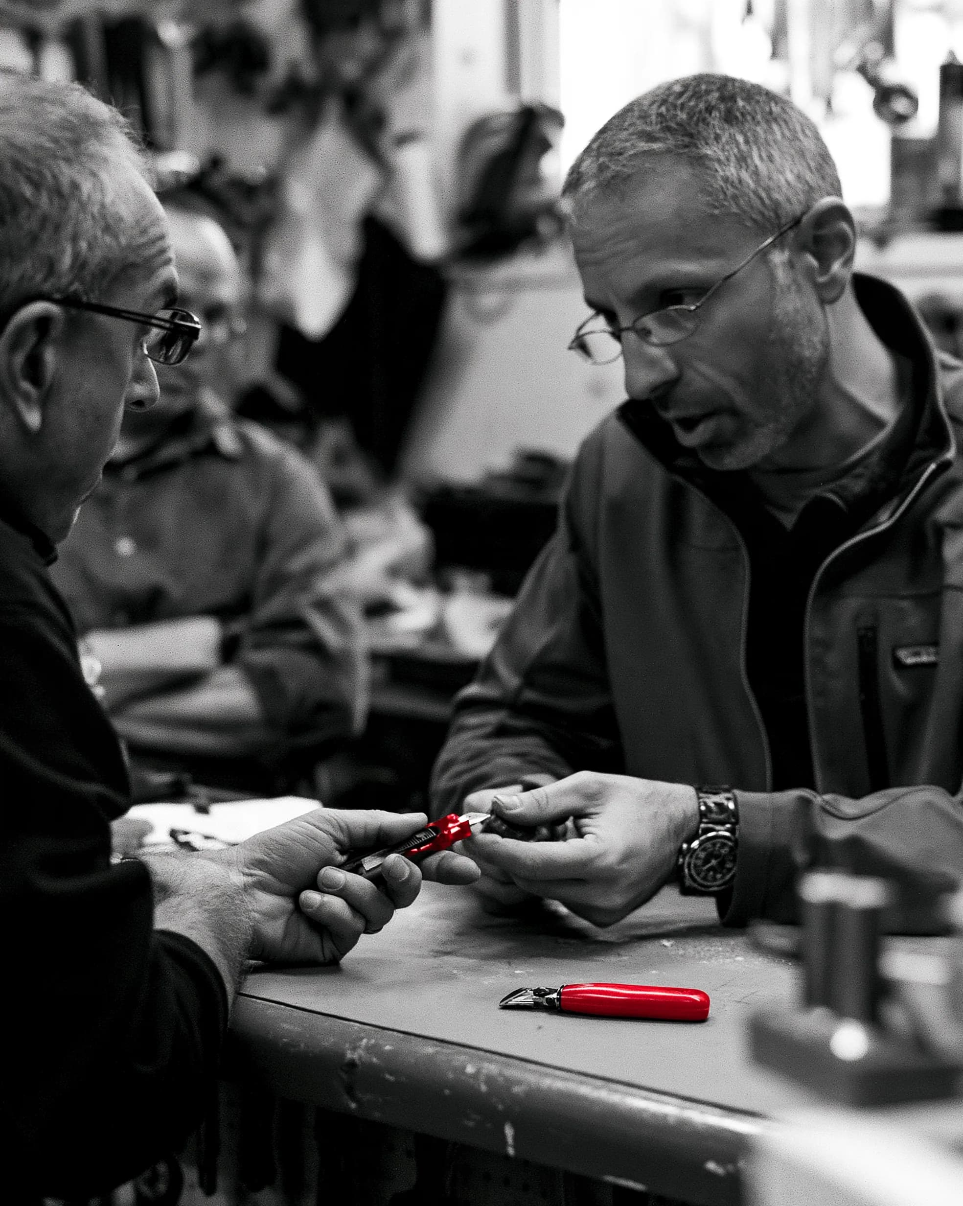 A founder showing a working prototype to a sceptical potential customer at the customer's premises